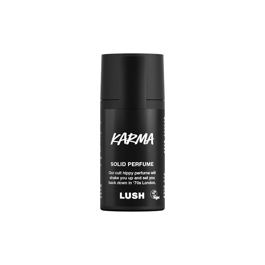 Karma. A short, cylindrical black push-up tube of the Karma solid perfume with a black label on the front covering the cap, with the product name and scent printed on it.